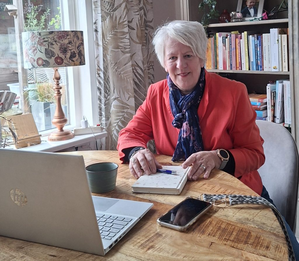 Foto van mij aan tafel achter mijn laptop