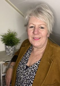 foto van mij staand in en bruin jasje met blouse